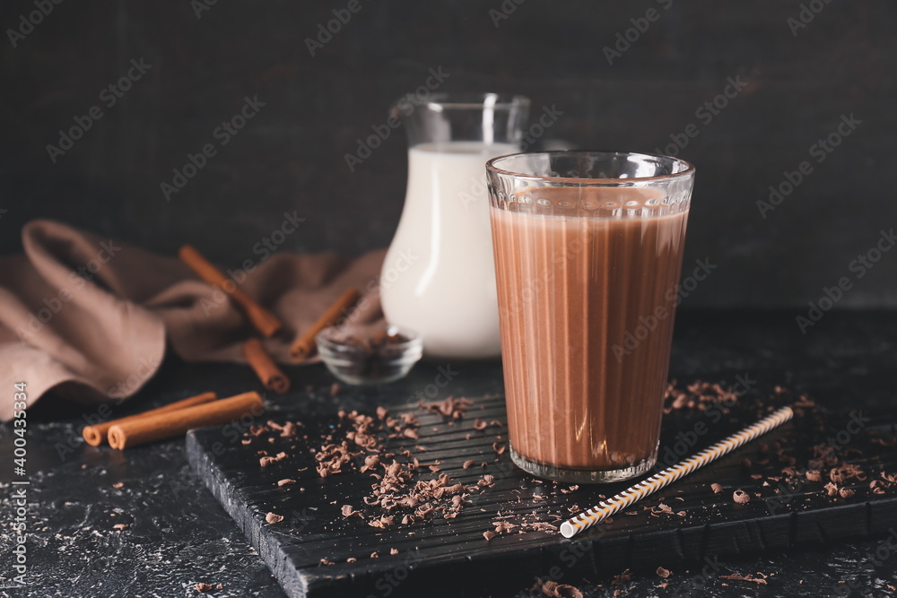 Glass of aromatic chocolate milk on dark background