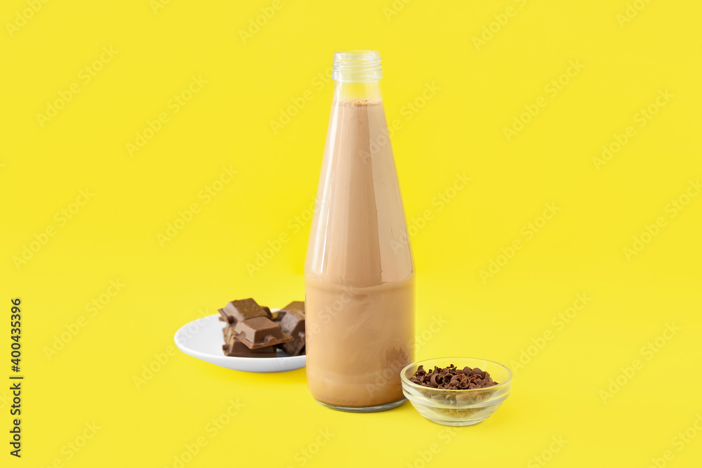 Bottle of tasty chocolate milk on color background