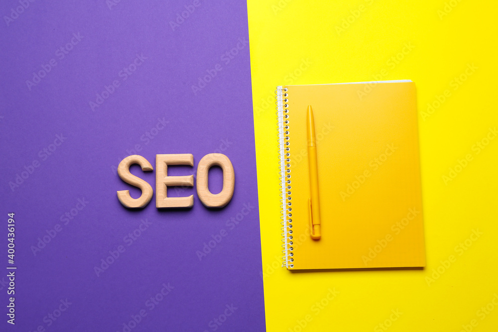 Abbreviation SEO with notebook and pen on color background