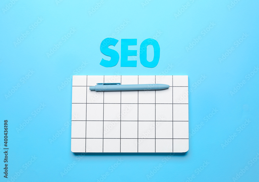 Abbreviation SEO with notebook and pen on color background