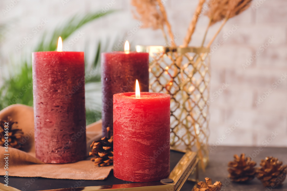 Beautiful aroma candles with Christmas decor on table