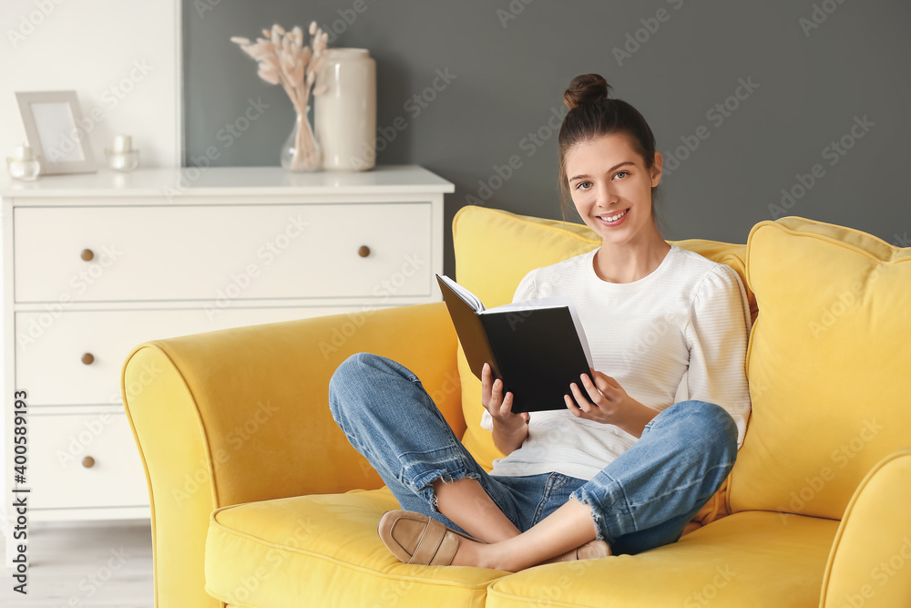 Young woman reading book at home