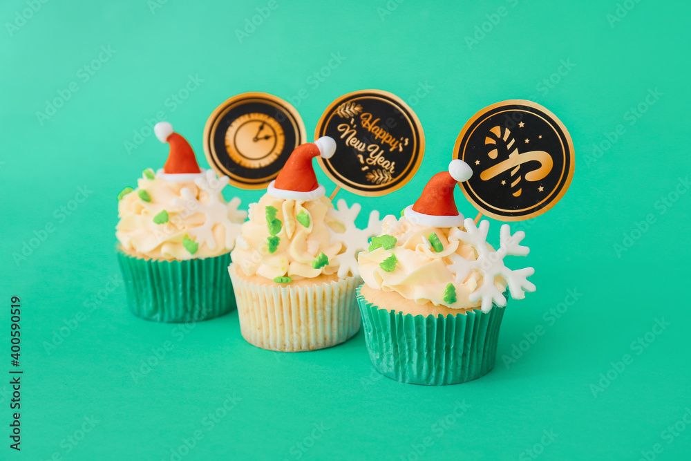 Tasty Christmas cupcakes on color background