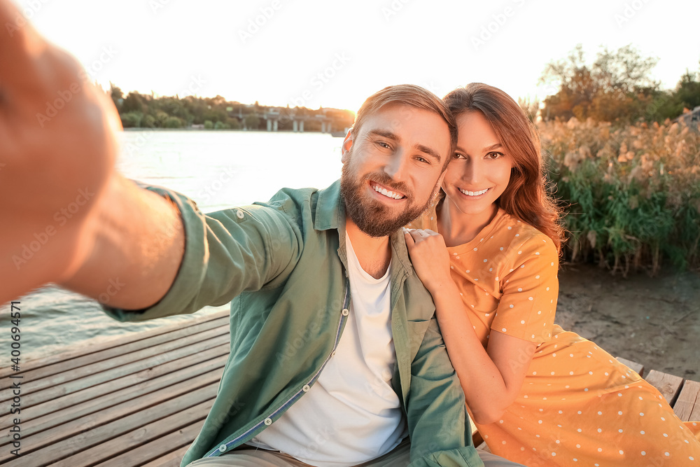 Young couple taking selfie near river