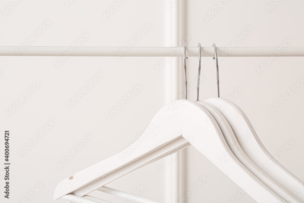 Rack with clothes hangers on white background