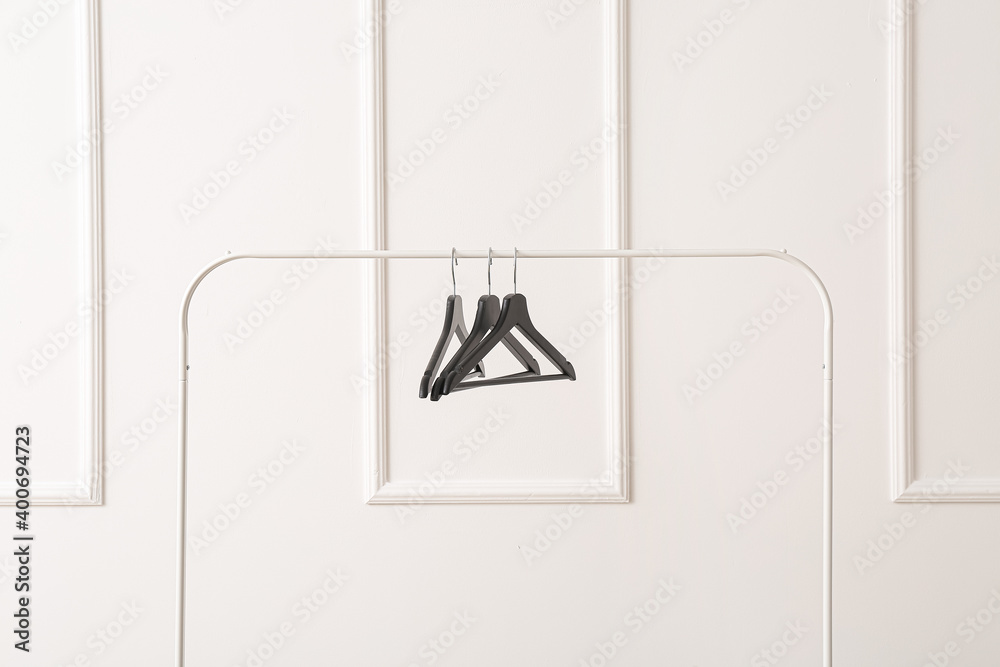 Rack with clothes hangers on white background