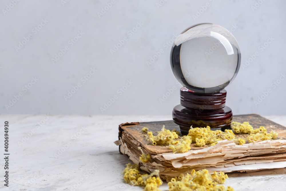 Crystal ball and spell book on table