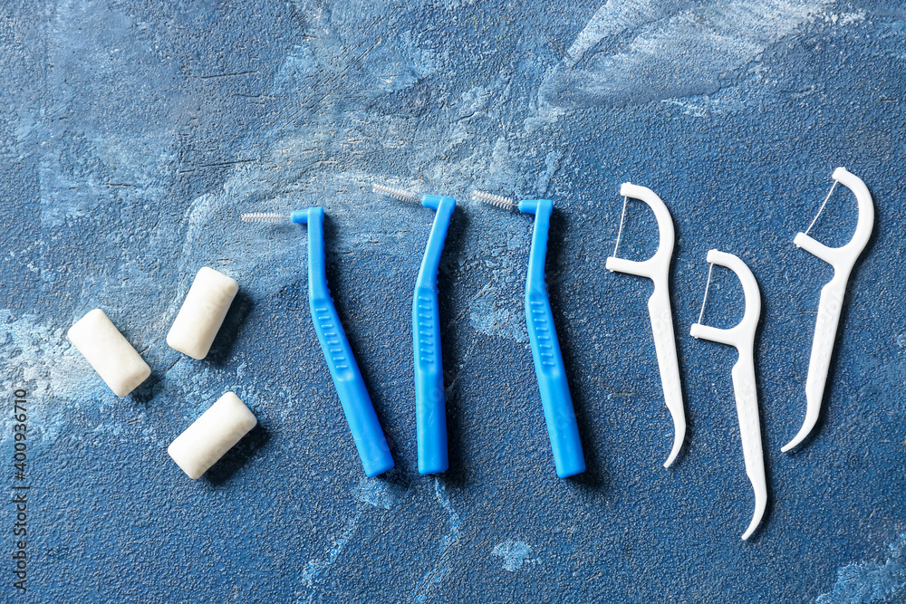 Toothbrushes for dental braces and floss picks on blue background