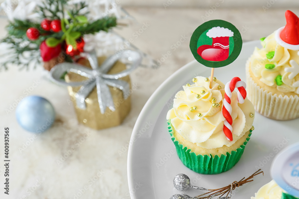 Dessert stand with tasty Christmas cupcakes on table