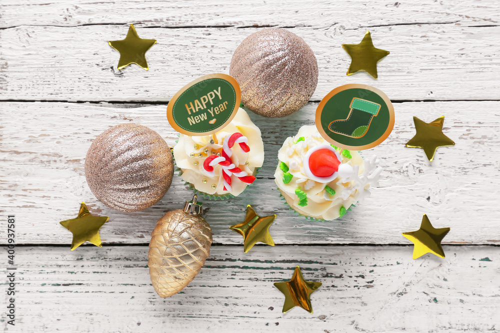 Tasty Christmas cupcakes on wooden background