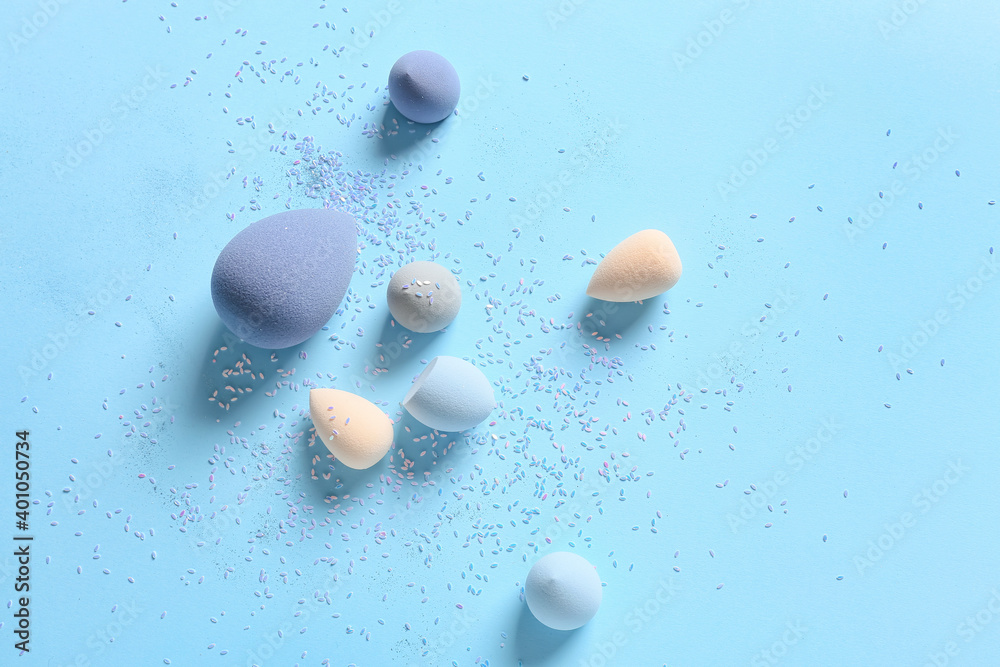 Colorful makeup sponges on color background