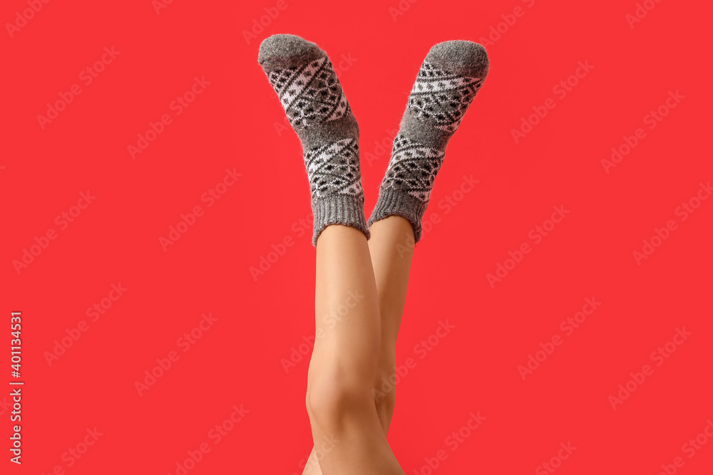 Legs of young woman in socks on color background