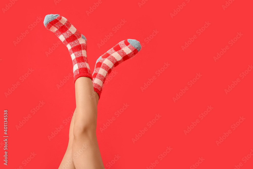 Legs of young woman in socks on color background