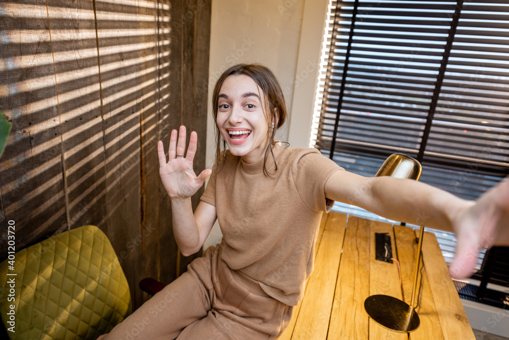 年轻开朗的女人穿着舒适的家居服，在家办公室进行视频通话