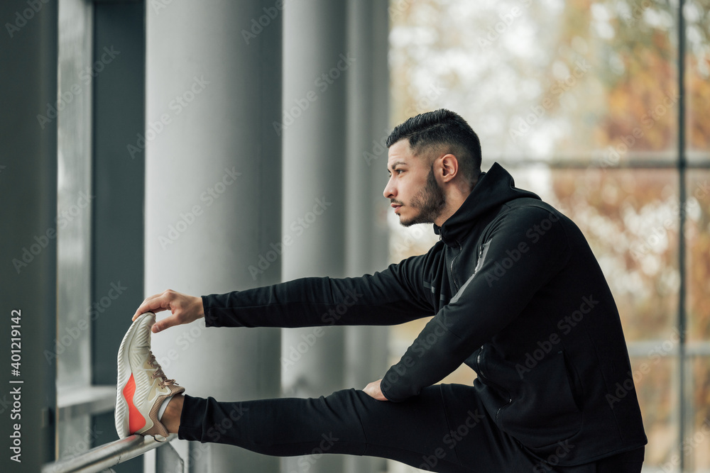 Man showing side profile, while doing stretching.