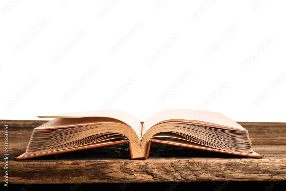 Open old book on table against white background