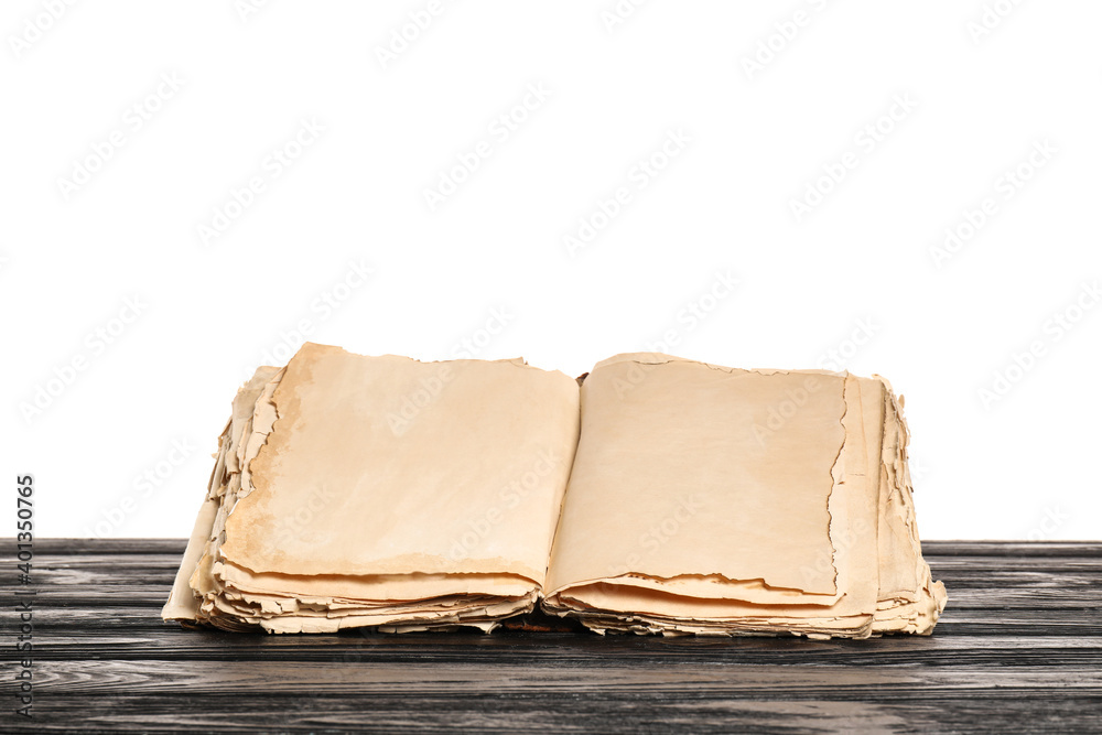 Open old book on table against white background