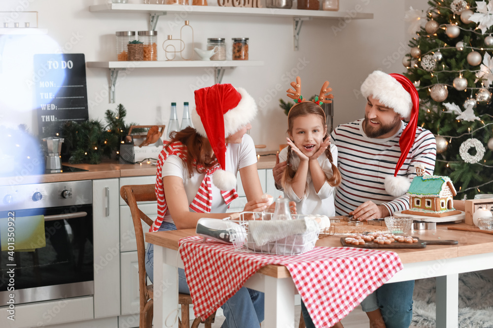 Happy family making tasty gingerbread cookies in kitchen on Christmas eve