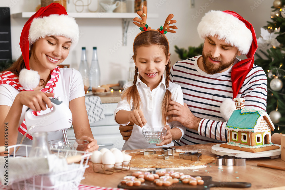 Happy family making tasty gingerbread cookies in kitchen on Christmas eve