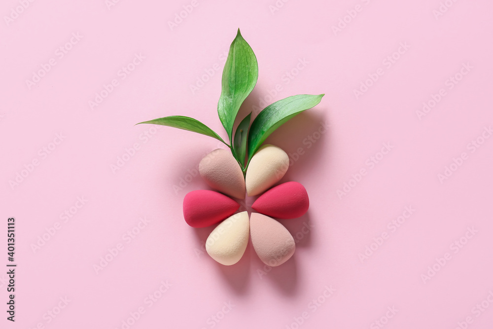 Flower made of makeup sponges on color background