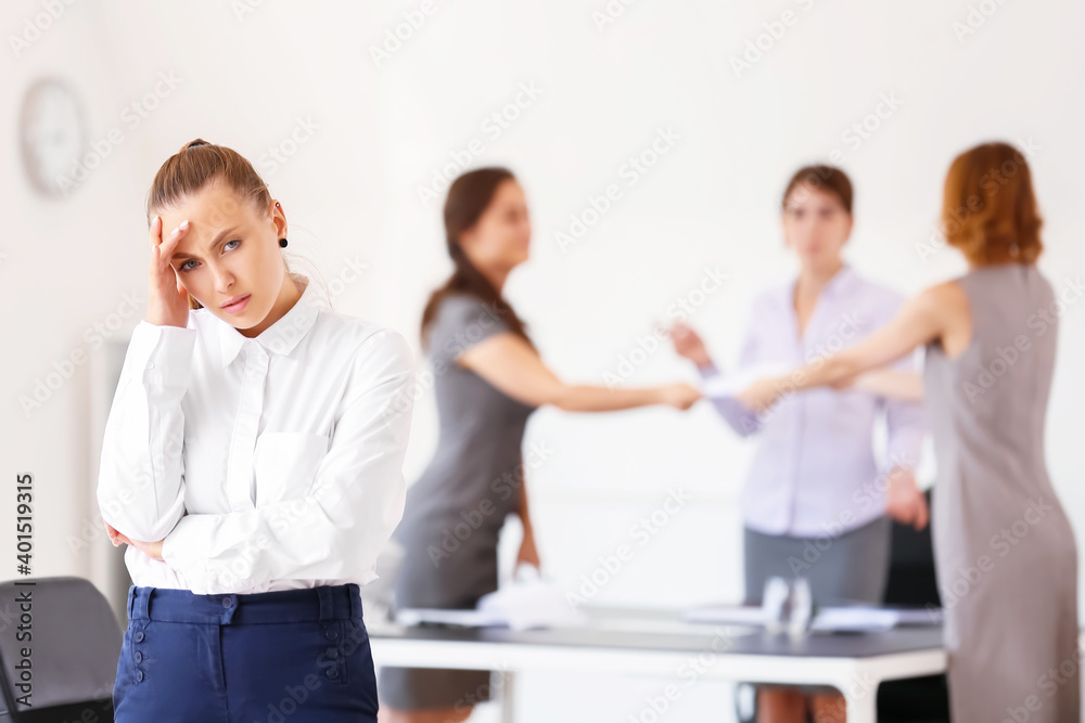 Stressed woman with headache and noisy people in office