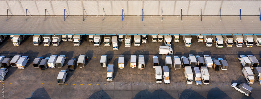 Aerial view logistics center in industrial city, Industrial warehouse loading dock where many truck 