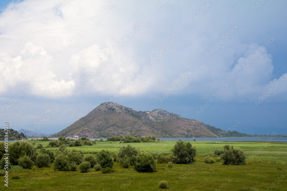 Green landscape with brown mountains under blue sky