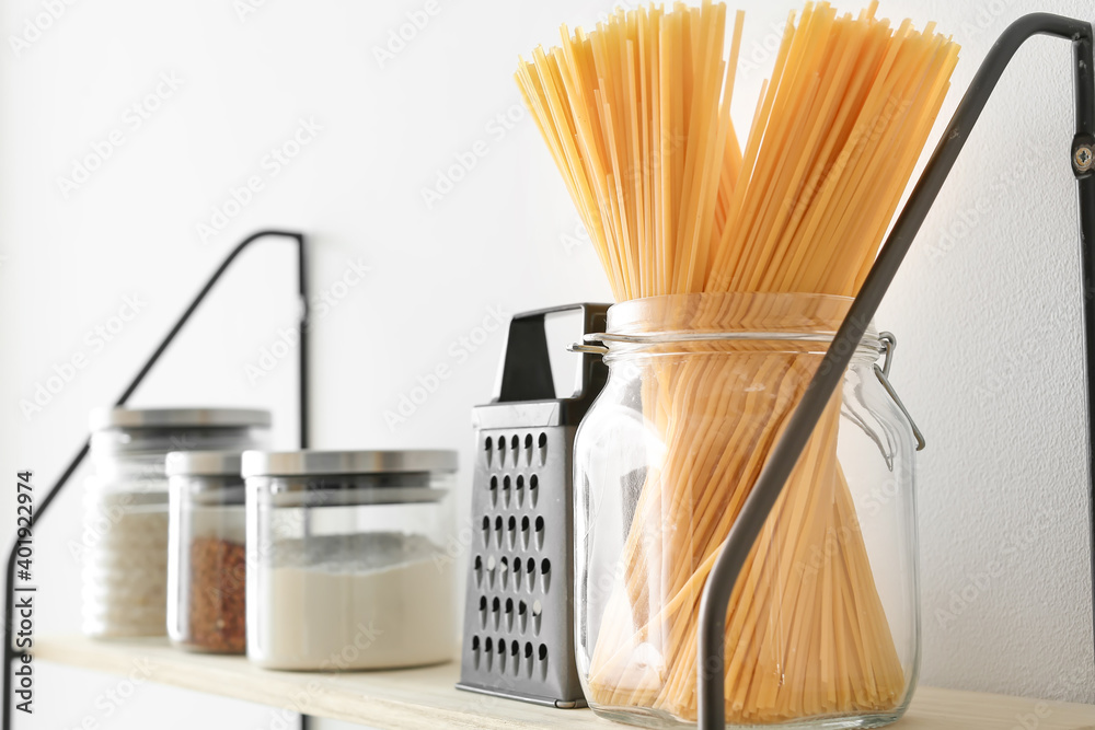 Jars with products on kitchen shelves