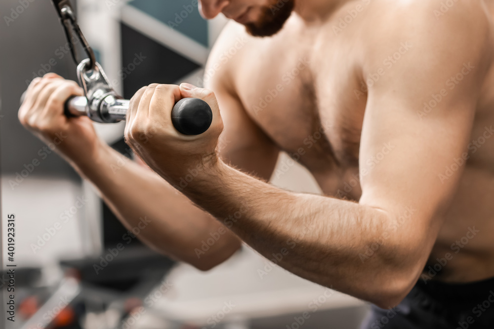 Handsome muscular man training in gym