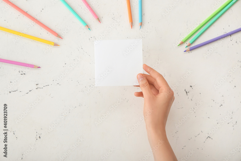 Female hand with blank paper on light background