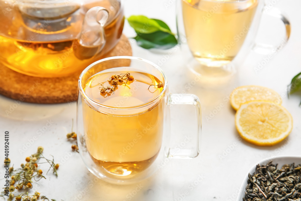 Cup of green tea with herbs on table