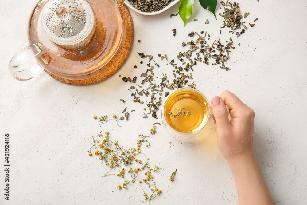 Female hand with cup of green tea on table