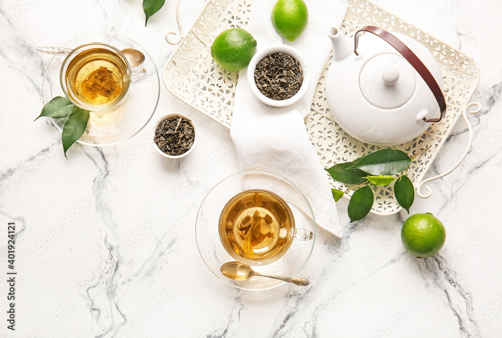 Composition with cups of green tea and teapot on table