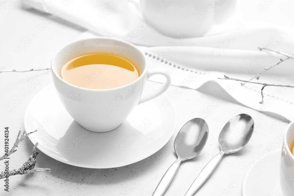 Cup of green tea and spoons on table