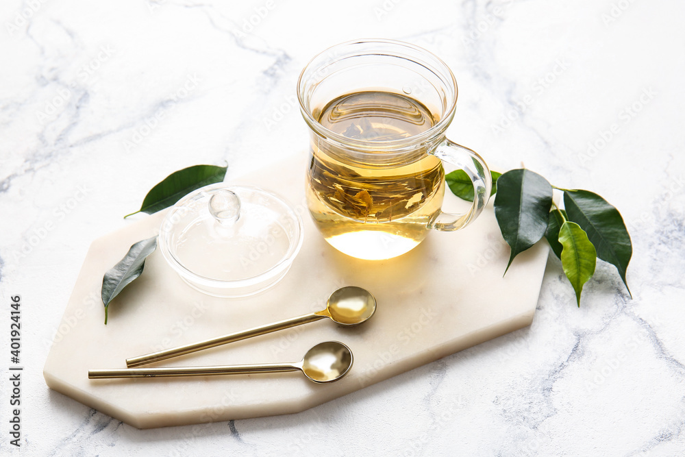 Cup of green tea and spoons on table