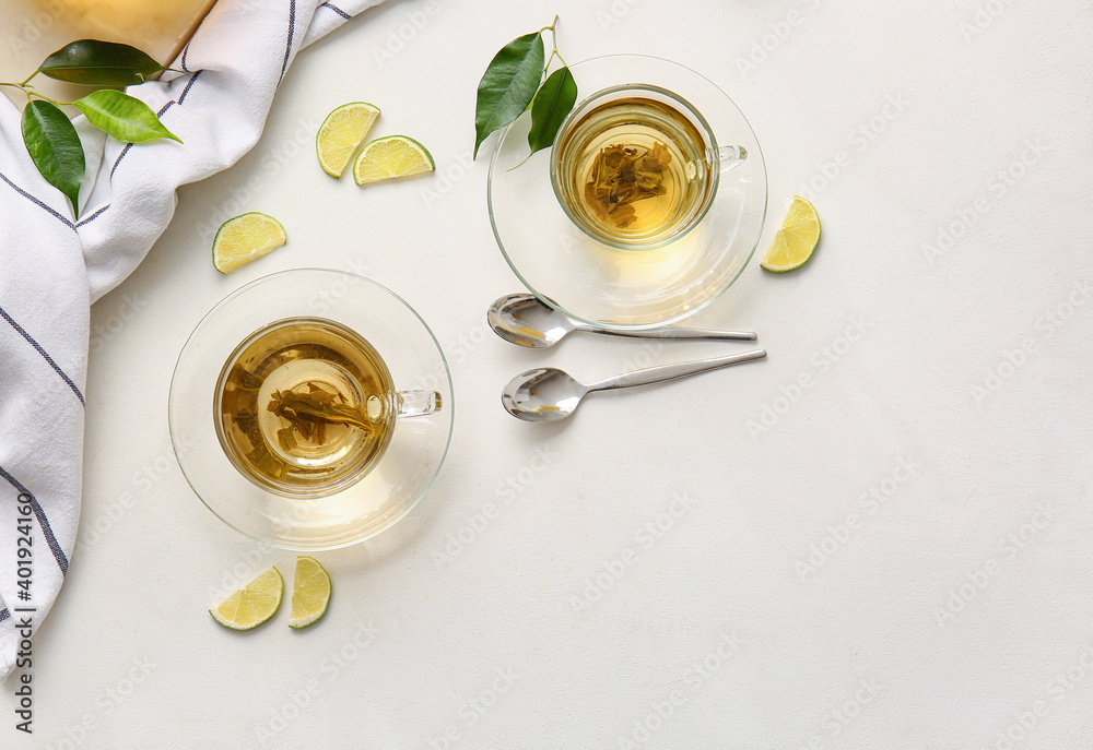 Composition with cups of green tea and lime on table