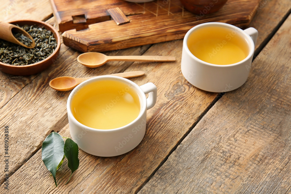 Composition with cups of green tea on wooden table