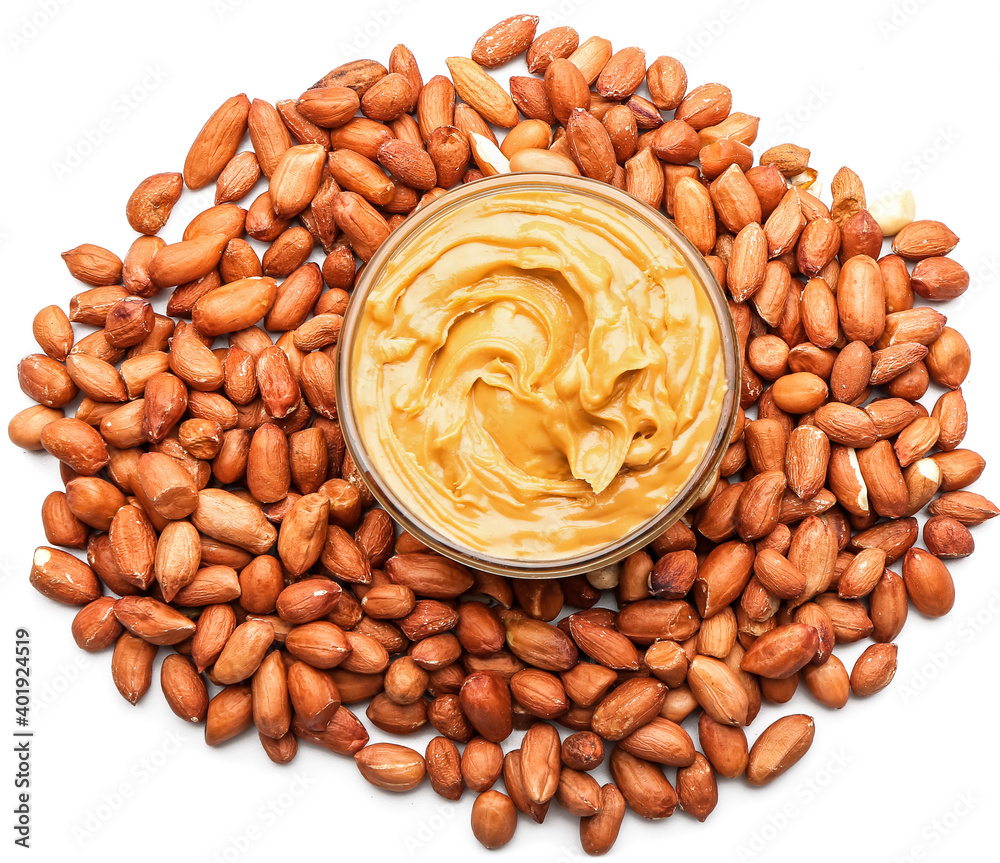 Bowl with tasty peanut butter and nuts on white background