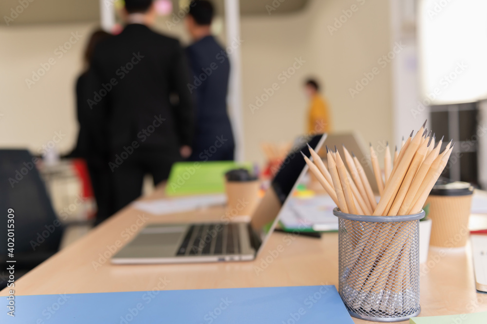 several pencils in box on blur  background of  businessman team