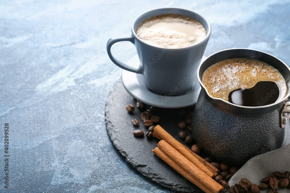 Board with cup of hot coffee and pot on table