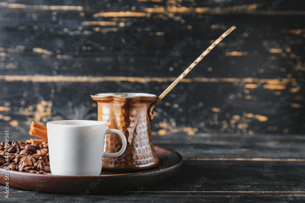 Pot and cup with hot coffee on wooden table