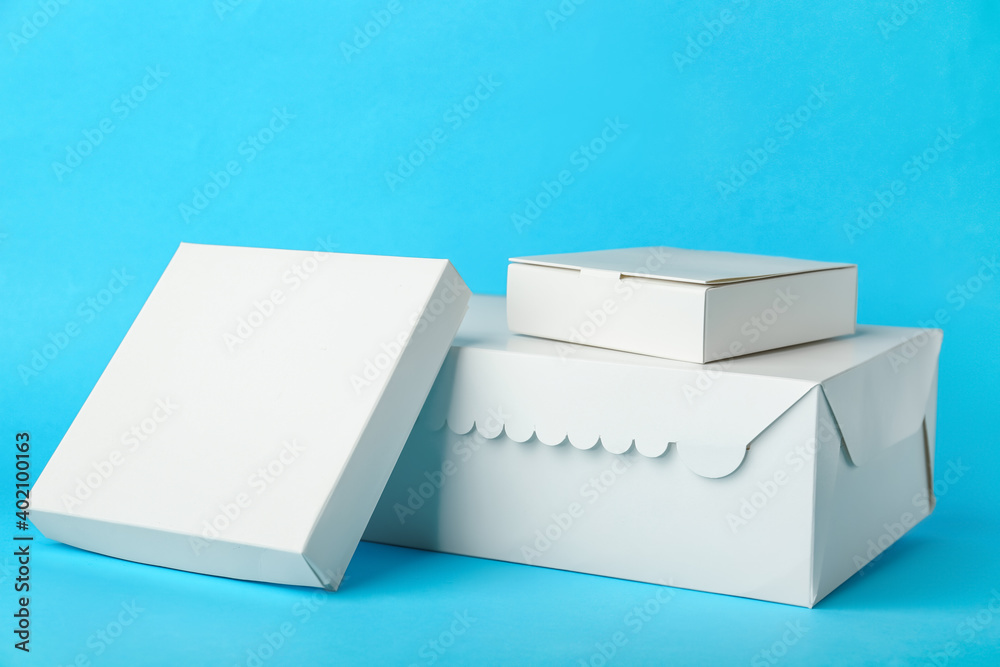 Blank cardboard boxes on color background