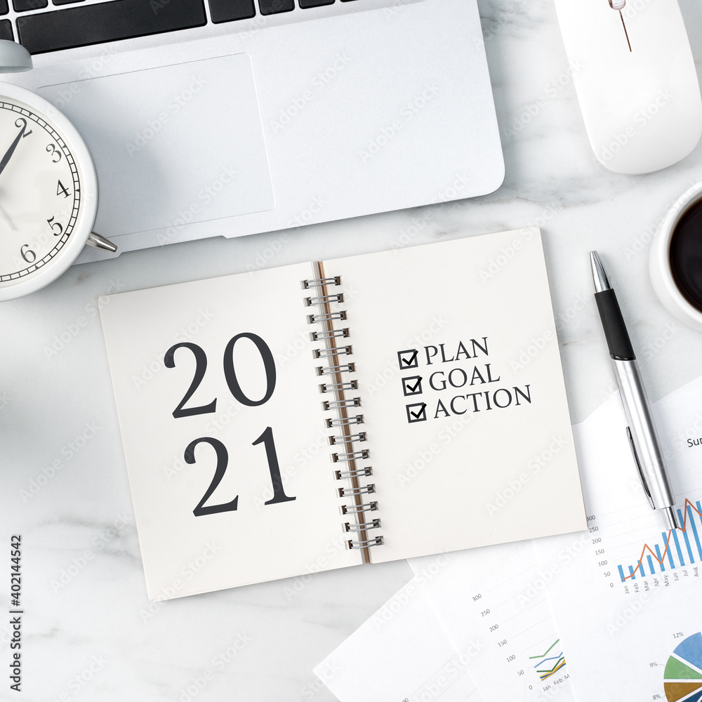 Top view of office table desk 2021 Goal work concept on bright marble white background.