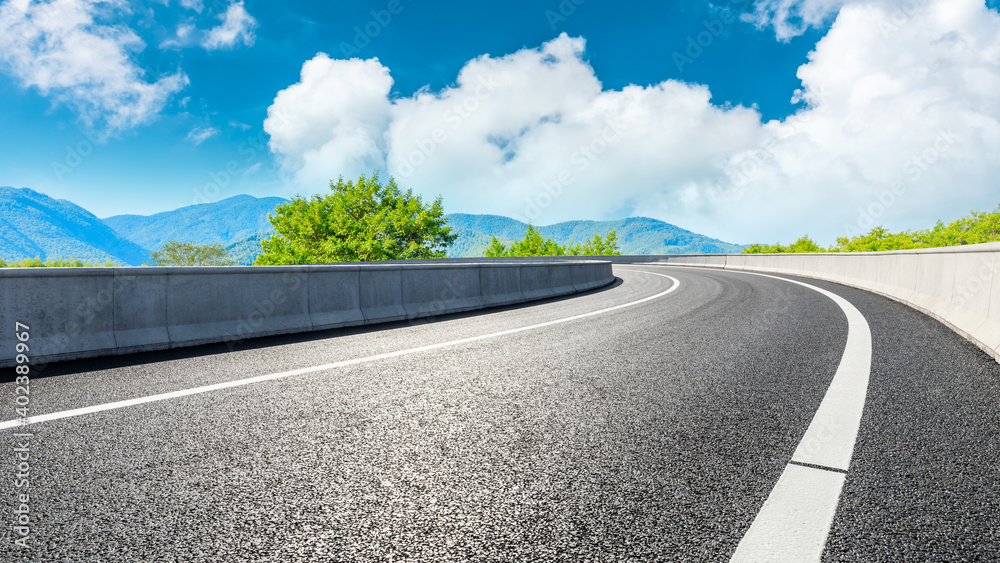 Asphalt road and green mountain under blue sky.Road and mountain background.