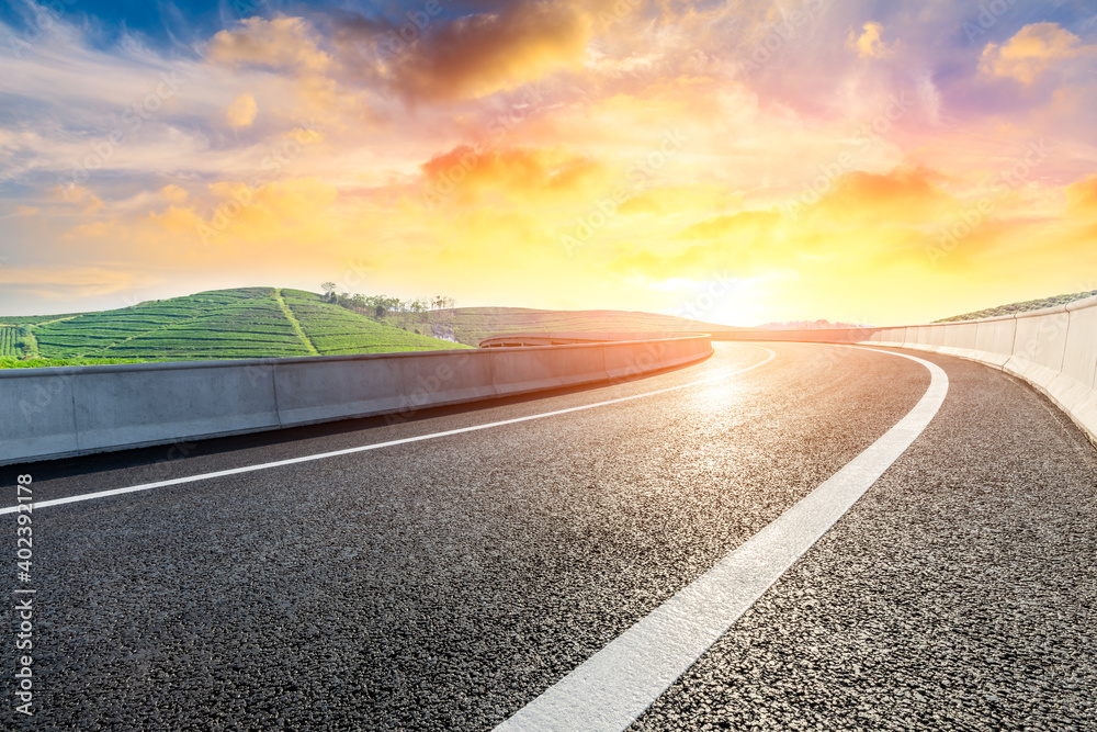 Asphalt road and mountain with tea plantation at sunset.Road and mountain background.