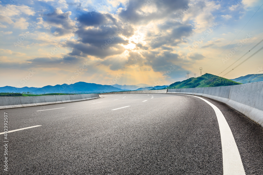 Asphalt road and mountain at sunset.Road and mountain background.