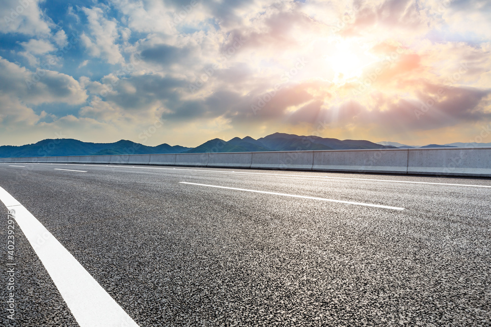 Asphalt road and mountain at sunset.Road and mountain background.