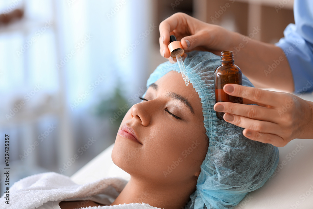 Young woman undergoing cosmetic procedure in beauty salon