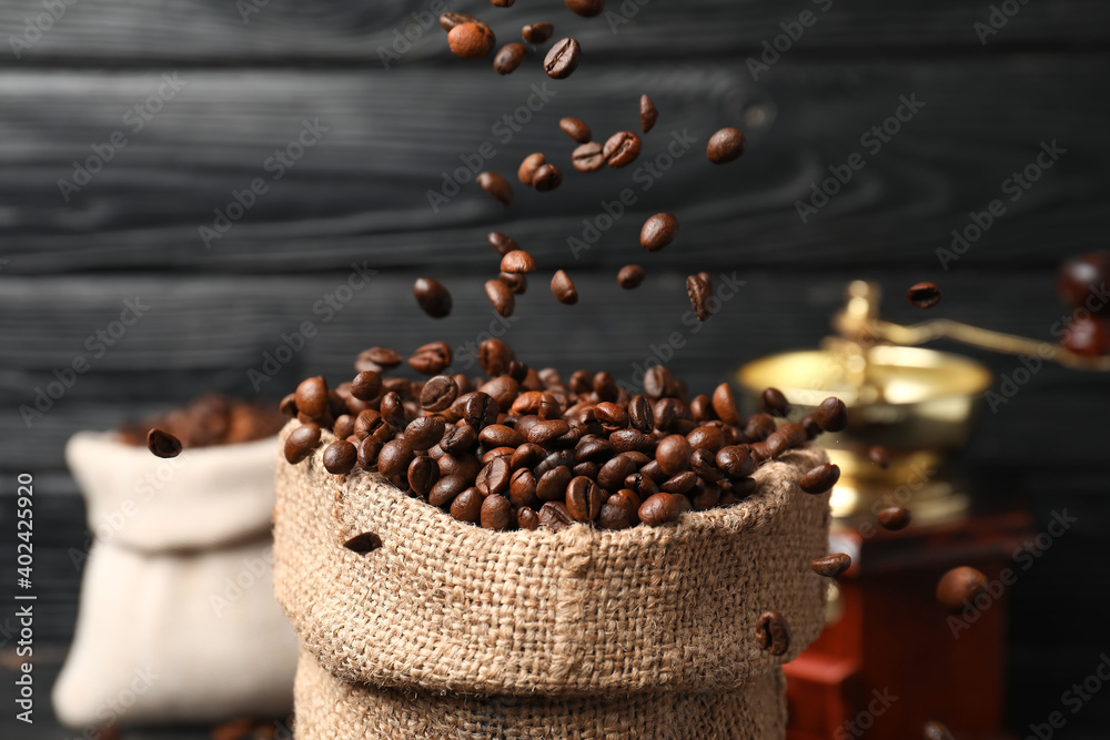 Bag with coffee beans on dark wooden background