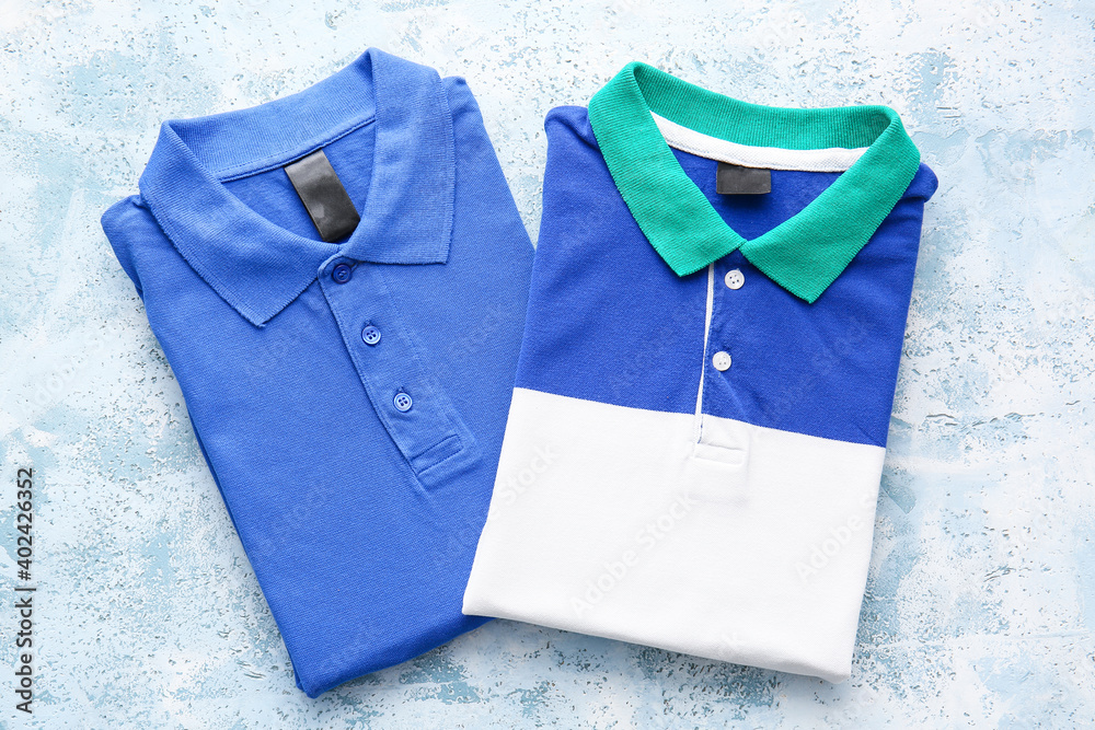 Folded polo shirts on light background